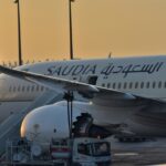 Saudia aircraft in a runway with sunset in the background