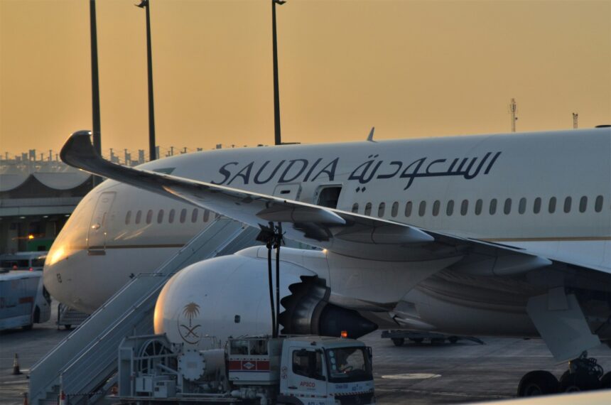 Saudia aircraft in a runway with sunset in the background