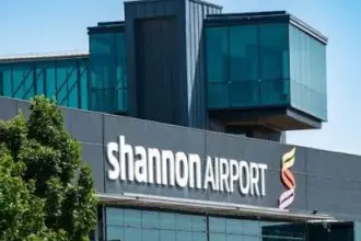 A woman with a suitcase and backpack walking through an airport car park