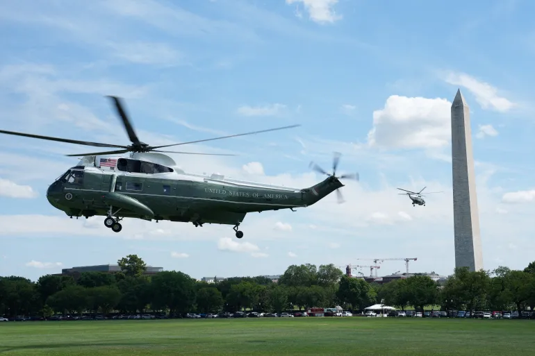 Full body picture of Marine one taking off another aircraft and the Washinton Monument captured behind it.