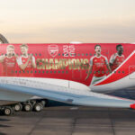 Photograph depicting exterior of Emirates aircraft on the runway emblazoned with Arsenal livery