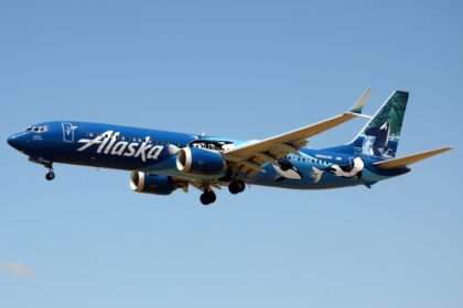 Alaska Airlines' Boeing 737-9 MAX in the air with its landing gear extended.