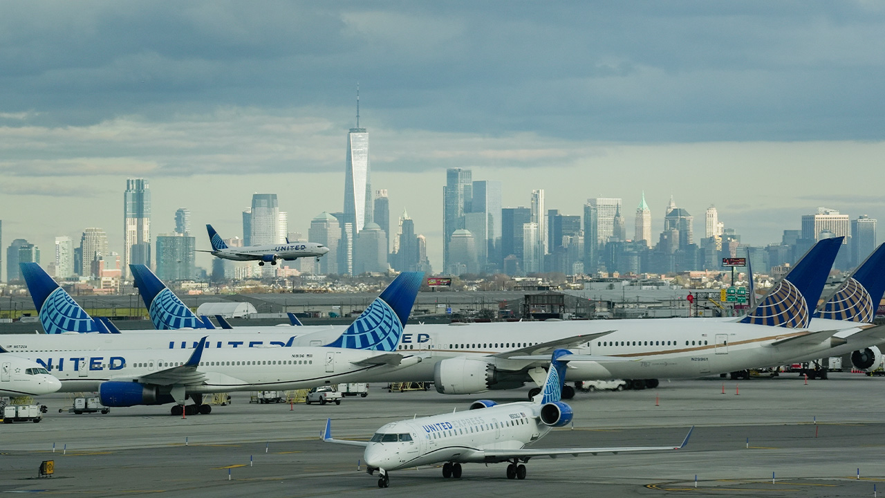 United Airlines airplanes on a tarmac with the New York City skyline in the background.