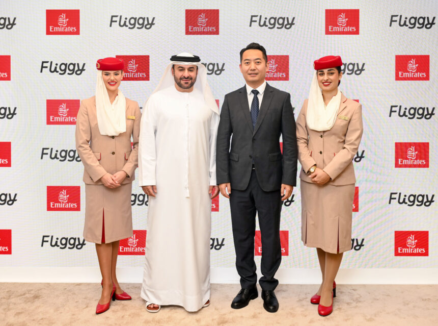 Four people stand next to each other in front of a promotional screen