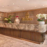 Photograph depicting the entrance to the Emirates lounge at Manchester airport staffed by Emirates worker.