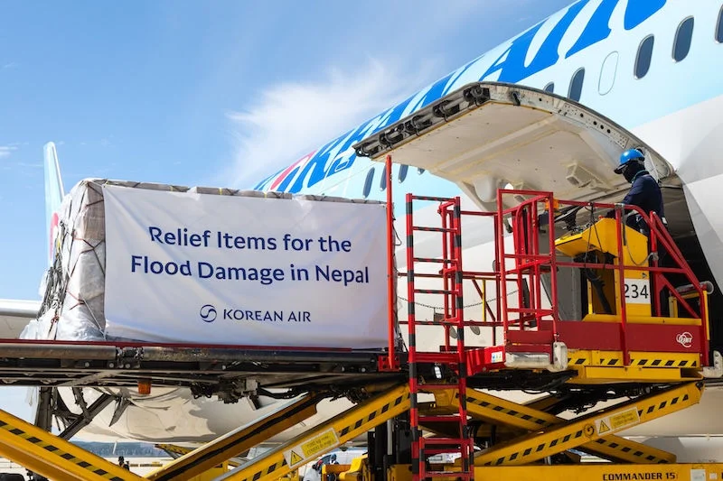 Image shows a Korean Air flight being loaded with emergency relief supplies for Nepal flood victims during the daytime