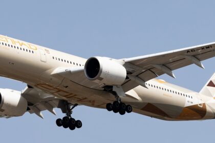 Etihad Airways' Airbus A350-1041 in the air with its landing gear extended.