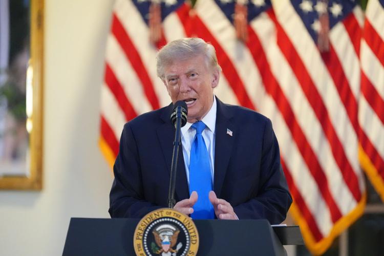 Donald Trump speaking into a microphone at a podium with the Seal of the President of the United States, flanked by American flags.