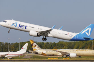 An A321neo aircraft taking off from the runway. An Etihad aircraft can be seen on the runway below the A321neo.