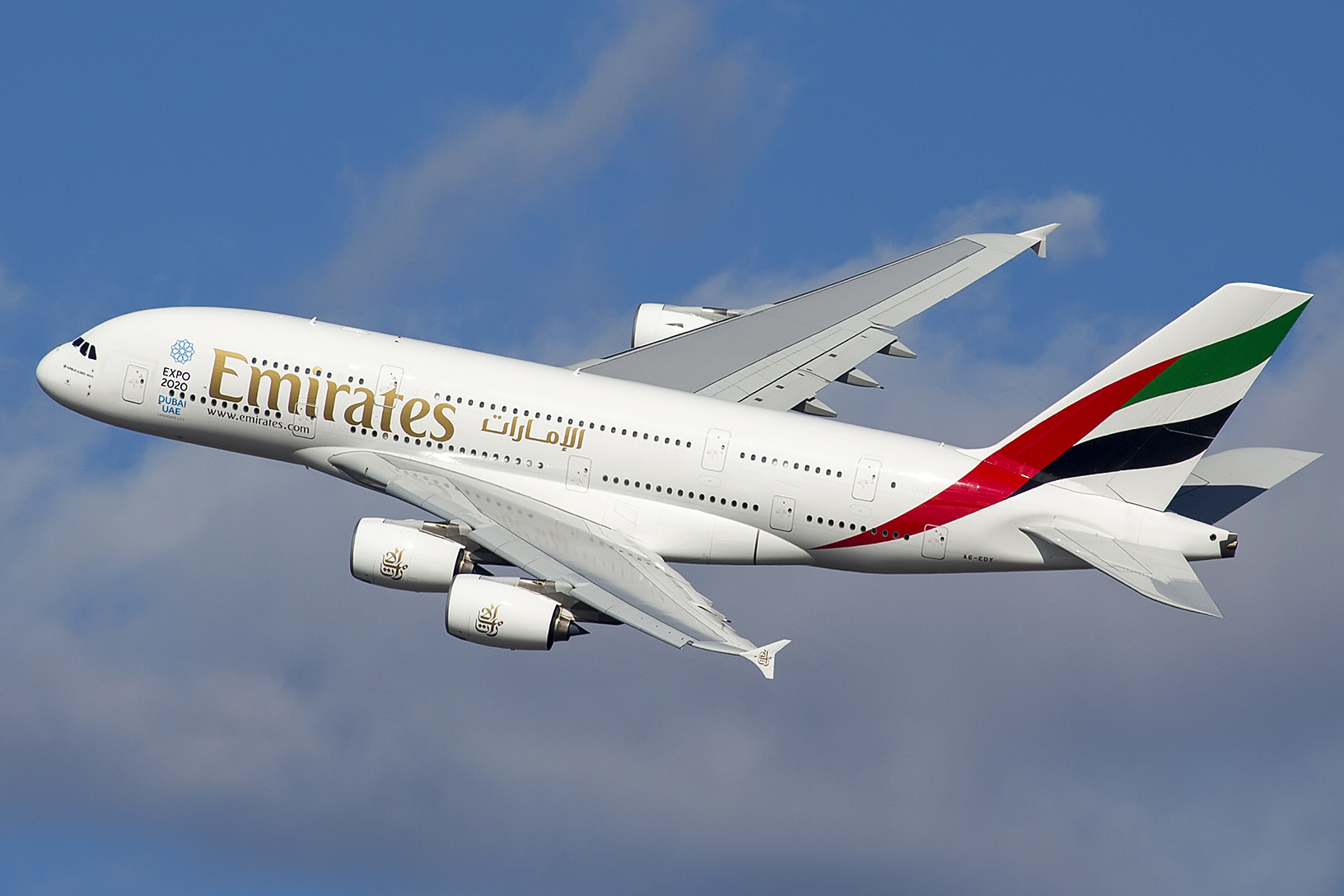 Emirates' Airbus A380 in the air with both wings and three engines visible.