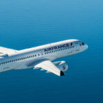 Photograph depicting the exterior of and Air France aircraft cruising at altitude above the ocean.