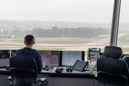 Image shows an air traffic controller looking out over runways.