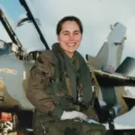 Jo Salter crouching in front of an aircraft wearing gear.