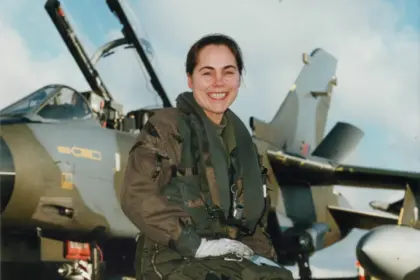 Jo Salter crouching in front of an aircraft wearing gear.