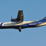 Buddha Air ATR 72 turboprop aircraft in flight with landing gear extended against a clear blue sky.