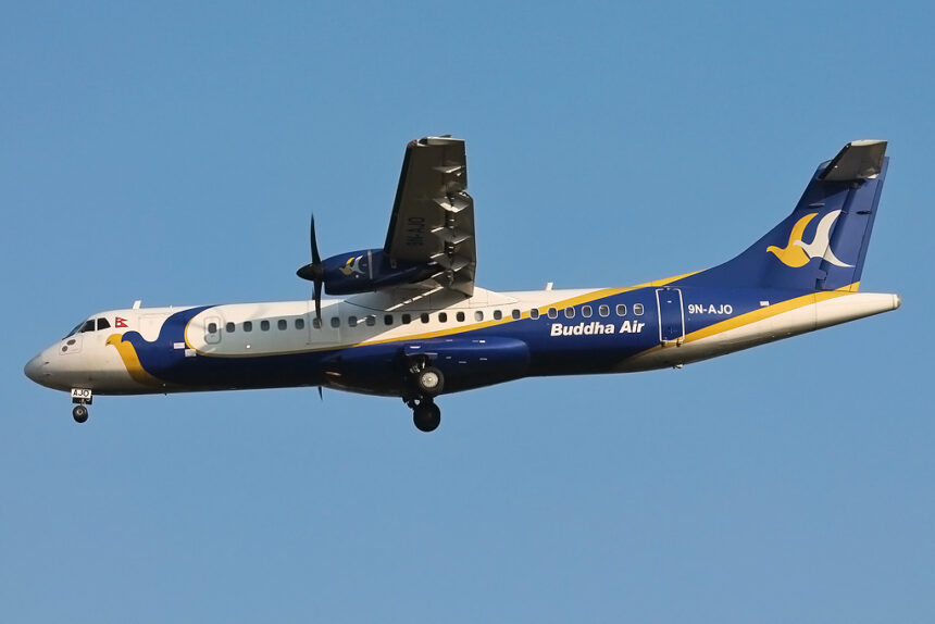 Buddha Air ATR 72 turboprop aircraft in flight with landing gear extended against a clear blue sky.