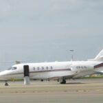 A Cessna Citation Latitude sitting on a runway, pictured from the side
