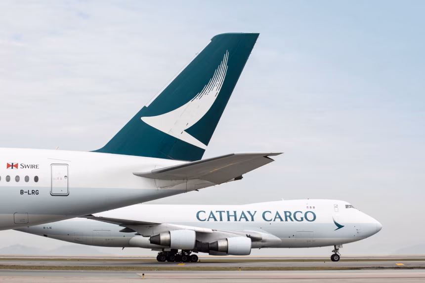 An image of two Cathay Cargo aircraft tail fin, with a Cathay Cargo Boeing 747 parked on the tarmac behind the tail wing aircraft
