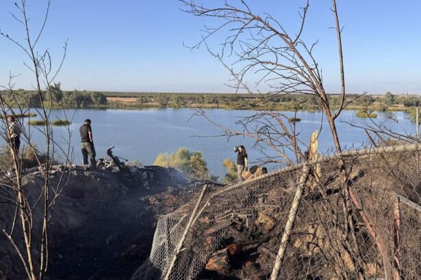 Emergency crews are pictured at the scene of the crash, overlooking the San Joaquin River on a sunny day.