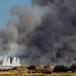 Tanagra Air Base is surrounded with heavy black smoke, as flames and other aircraft can be seen at the Athens Flying Week show.