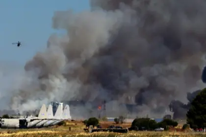 Tanagra Air Base is surrounded with heavy black smoke, as flames and other aircraft can be seen at the Athens Flying Week show.