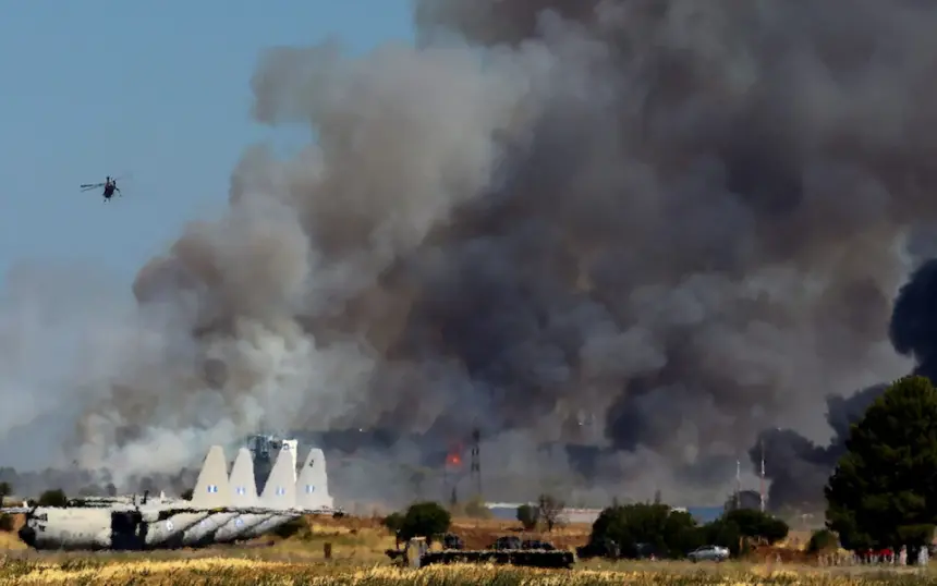 Tanagra Air Base is surrounded with heavy black smoke, as flames and other aircraft can be seen at the Athens Flying Week show.