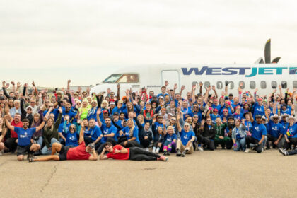 Image shows a large number of people at the Haul for Hope fundraising event at Calgary International Airport with a WestJet aircraft behind them