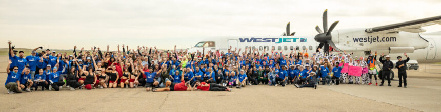 Image shows a large number of people at the Haul for Hope fundraising event at Calgary International Airport with a WestJet aircraft behind them