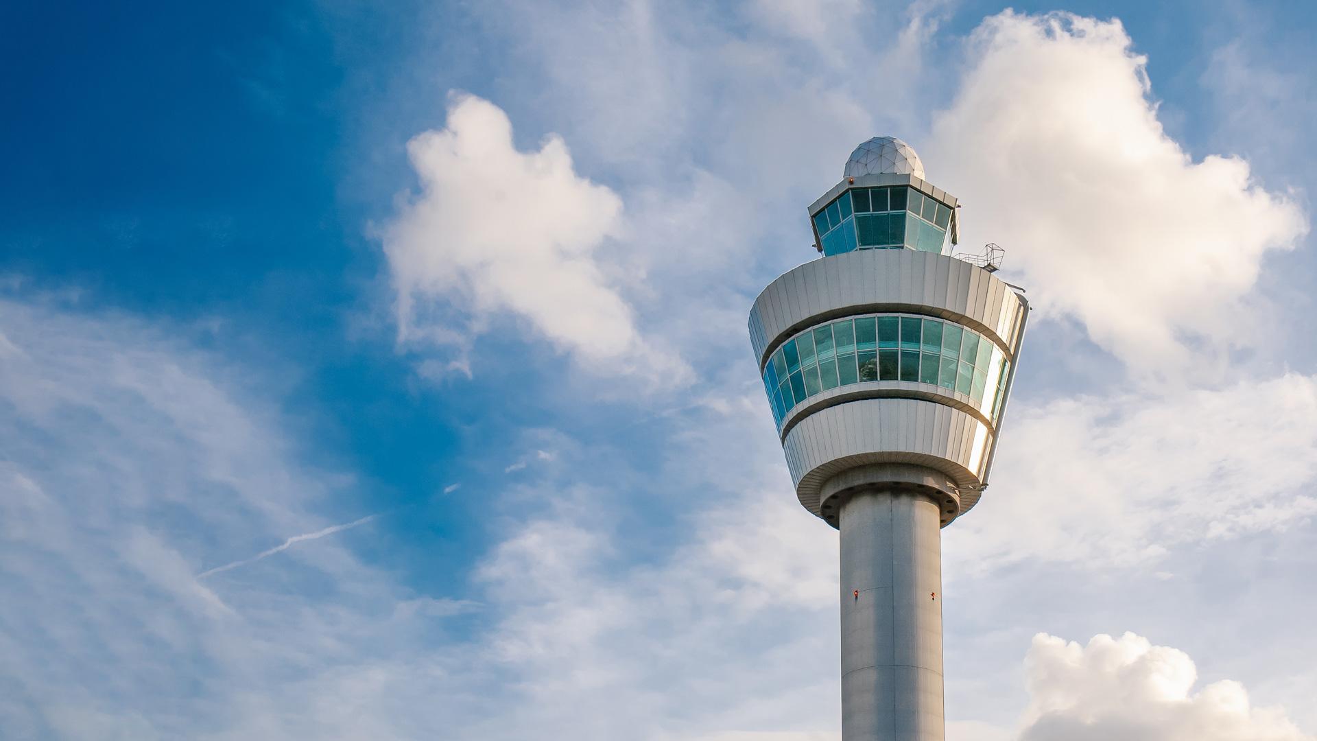 A control tower at Amsterdam Airport Schipol (AMS) on a cloudy day.
