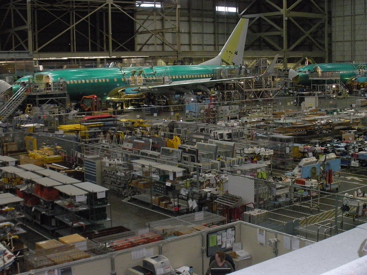 Boeing’s wing production facility in Renton. A green jet is seen on the far side of a warehouse.