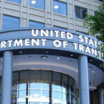 The headquarters of the U.S. Department of Transportation in Washington. The department’s name is written in gold letters, in front of grey stone.