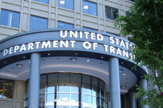 The headquarters of the U.S. Department of Transportation in Washington. The department’s name is written in gold letters, in front of grey stone.