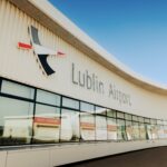 The terminal building at Lublin Airport (LUZ). The building is made of white stone, with clear windows, beneath a clear blue sky.