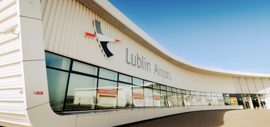 The terminal building at Lublin Airport (LUZ). The building is made of white stone, with clear windows, beneath a clear blue sky.