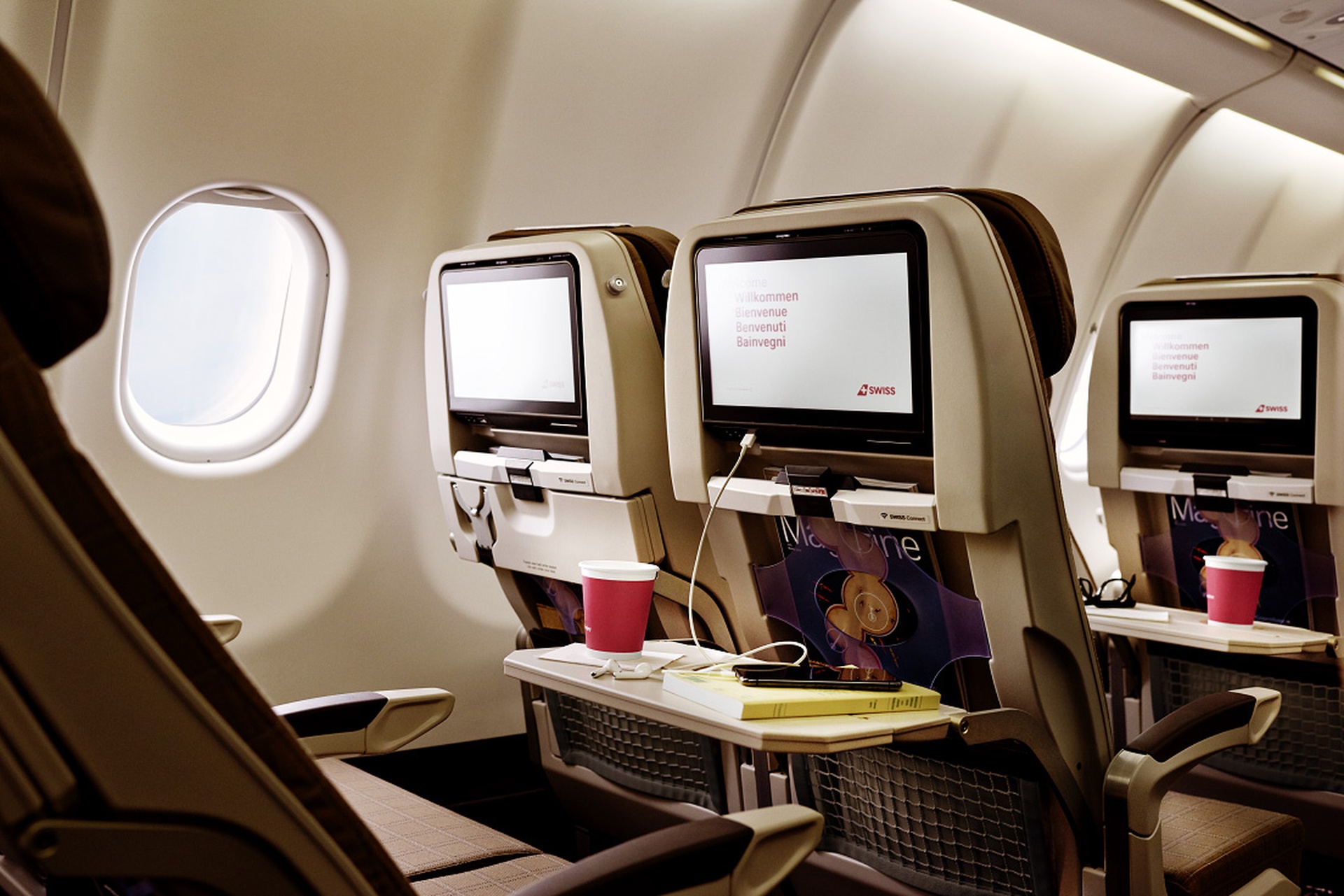 Photograph depicting interior of the refurbished SWISS Airbus A340 with an overview of the inflight entertainment screens. 