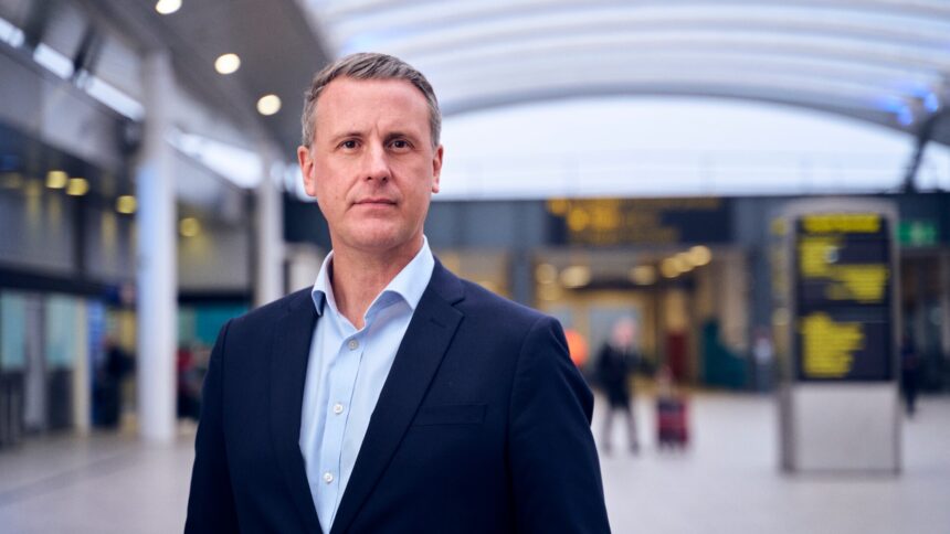 Image shows Mark Johnston, COO of Gatwick Airport in the foreground with a blurred airport in the background