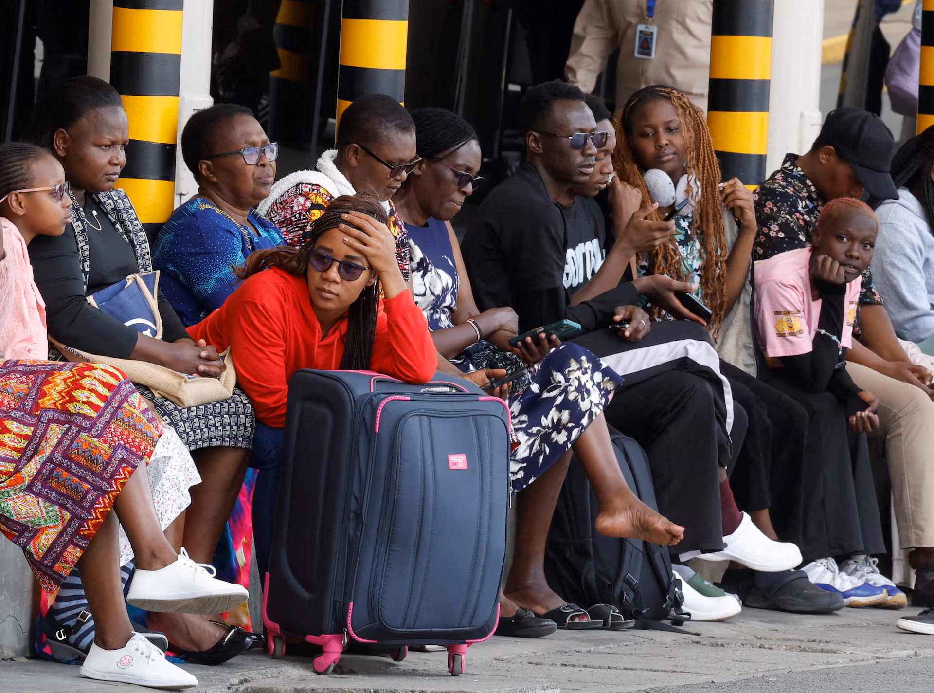 Stranded travelers sitting and waiting with their luggage after flights were canceled due to the strike at the Jomo Kenyatta International Airport in Nairobi, Kenya.