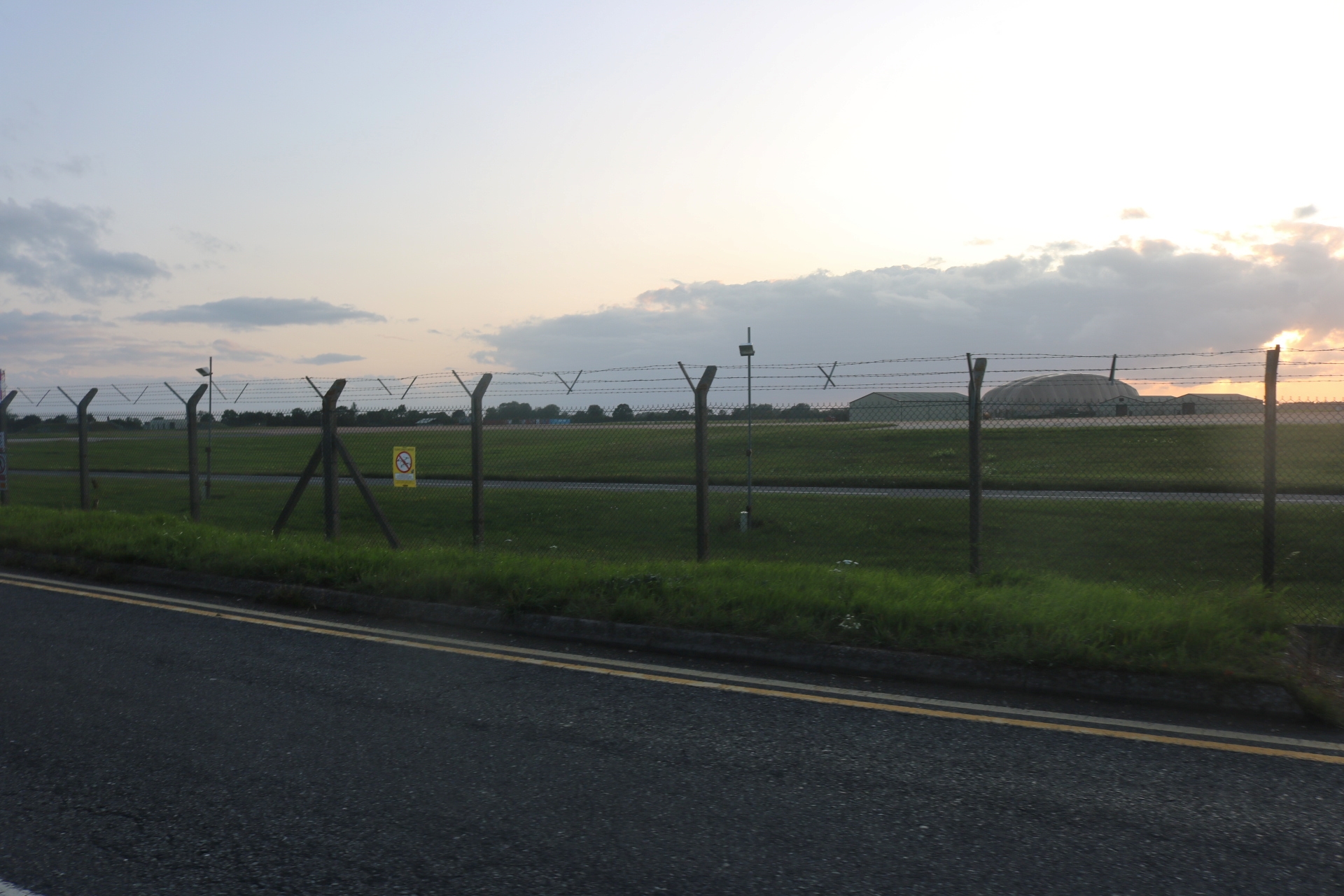 Image shows the airfield of RAF Fairford from behind a fence.