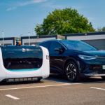 A Stanley Robotics valet robot, numbered 12, is parked alongside a black Volkswagen in the allocated lot at London Gatwick Airport (LGW).