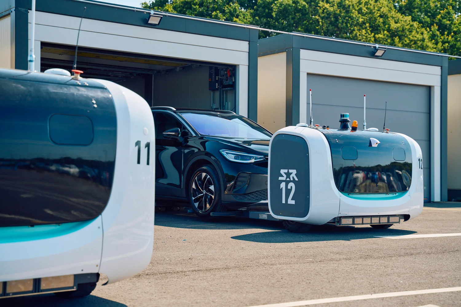 Robot 12 is picture pushing a black Volkswagen into one of the secure units.