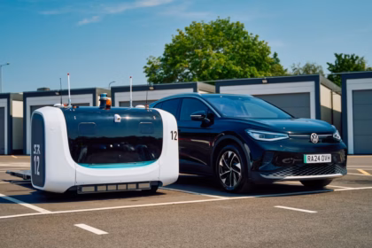 A Stanley Robotics valet robot, numbered 12, is parked alongside a black Volkswagen in the allocated lot at London Gatwick Airport (LGW).