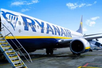 A Ryanair Boeing 737-800 parked on an airport terminal, with the stairs lowered.