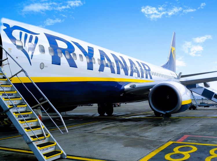 A Ryanair Boeing 737-800 parked on an airport terminal, with the stairs lowered.