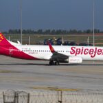 A SpiceJet Boeing 737-800 with its bright fiery red and orange design that features a dotted pattern at the tail of the aircraft.