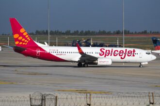 A SpiceJet Boeing 737-800 with its bright fiery red and orange design that features a dotted pattern at the tail of the aircraft.