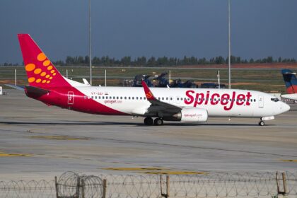 A SpiceJet Boeing 737-800 with its bright fiery red and orange design that features a dotted pattern at the tail of the aircraft.