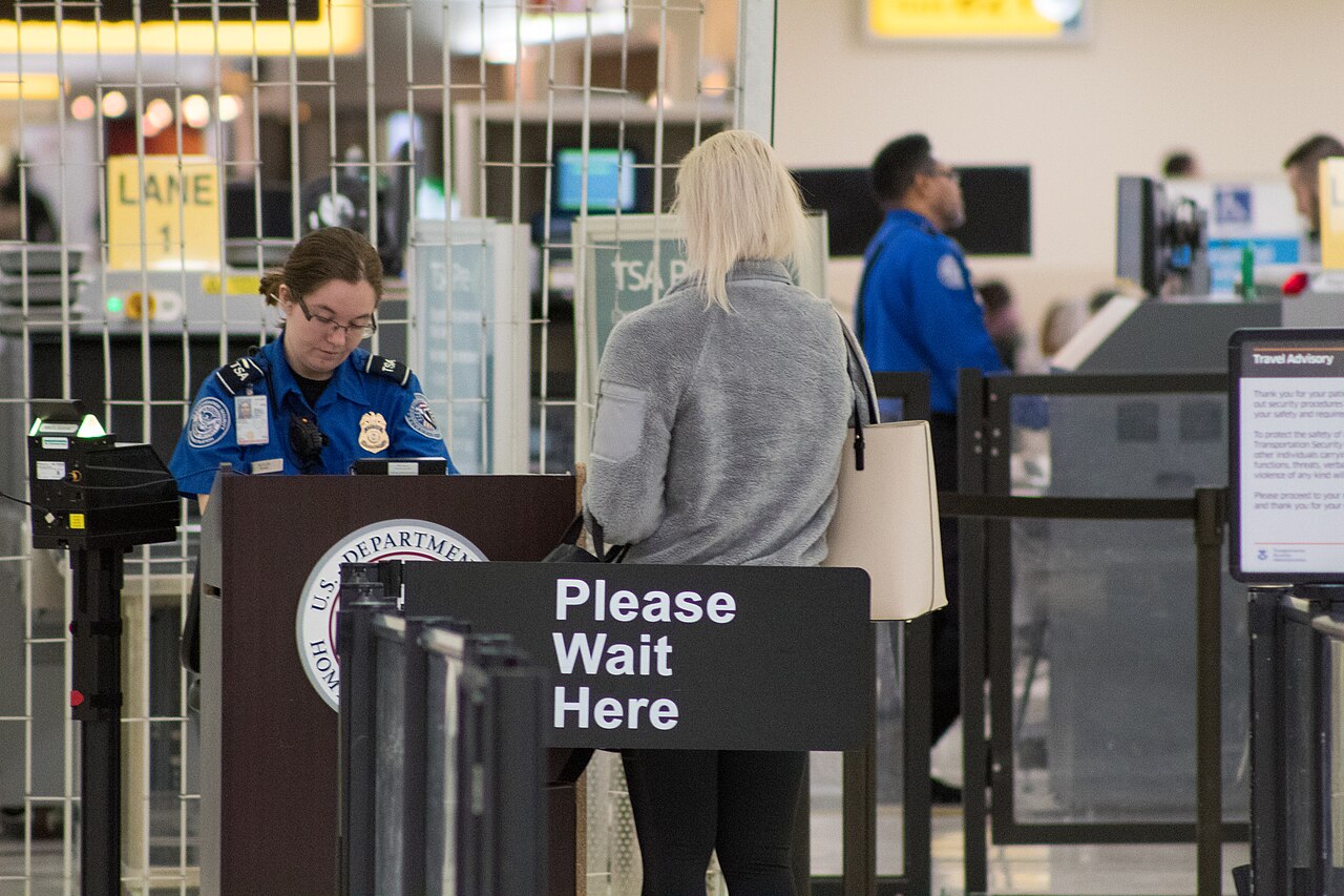 A TSA officer checking identification at John Glenn Columbus International Airport