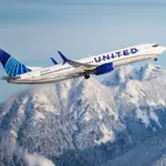 United Airlines aircraft taking off with mountains in the background.