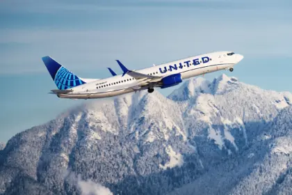 United Airlines aircraft taking off with mountains in the background.