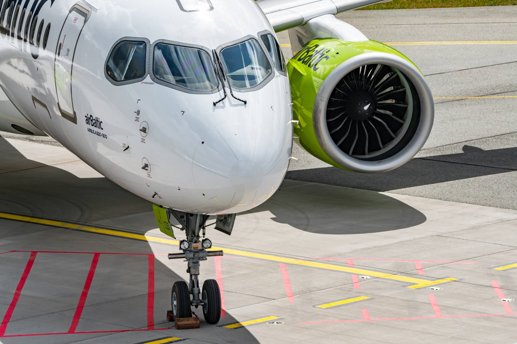An close-up picture of an airBaltic aircraft parked in an airport runaway